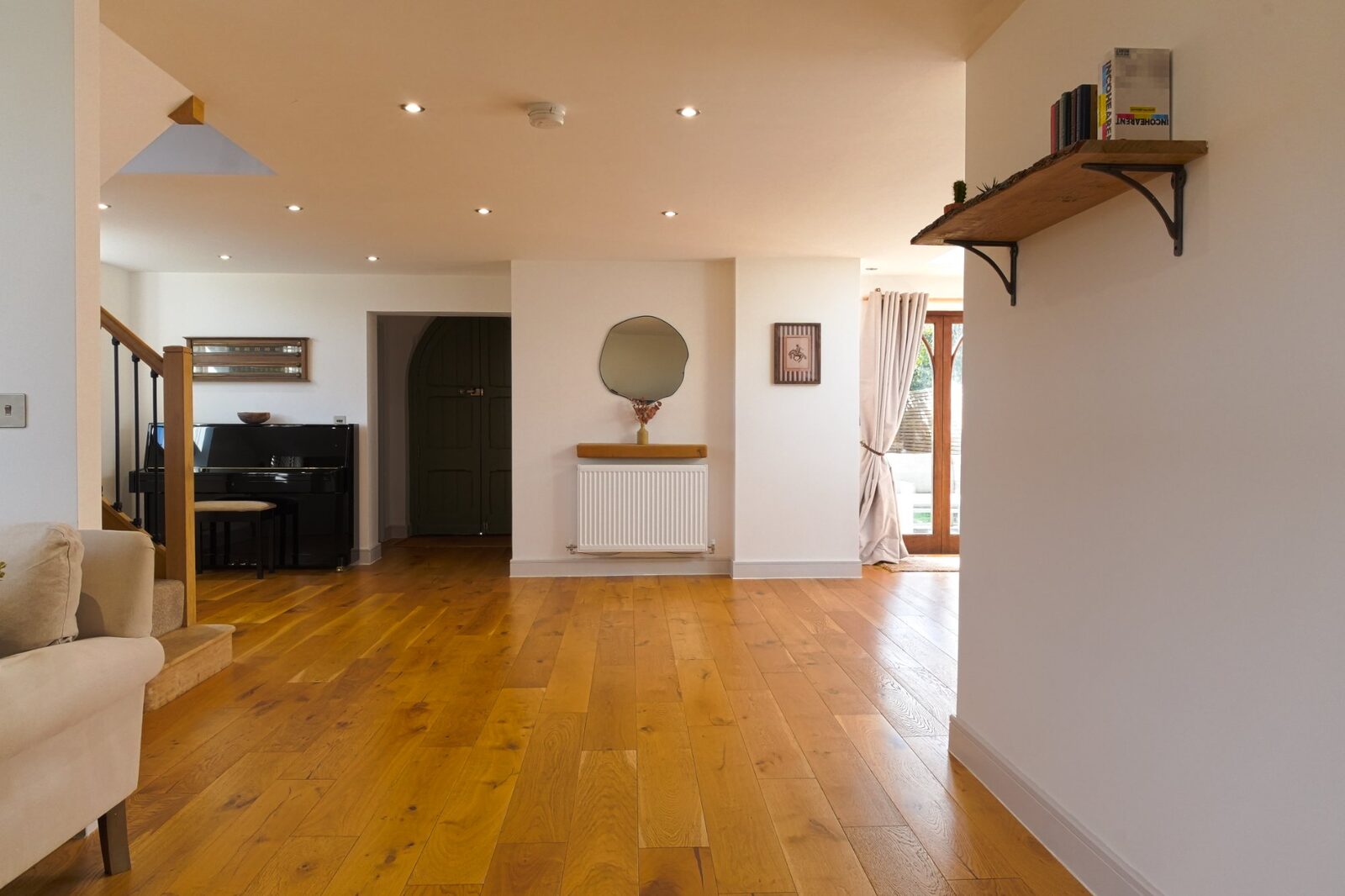 Open-plan living and dining space with piano and Gothic doors