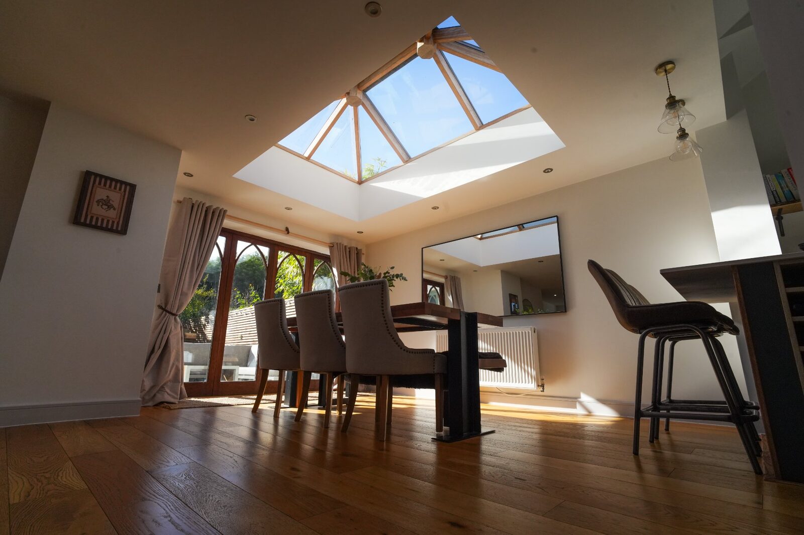 Dining area flooded with light from lantern roof